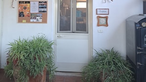 A reception area with a bulletin board, a decorative wall piece, and potted plants. - Agriturismo La Tortorella (Grosseto)