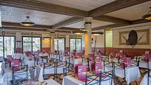 Restaurante com várias mesas, cada uma com menus e copos.