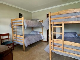 Una habitación con dos literas, un escritorio de madera y una silla.
