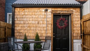 A brick building with a black door, a number 23085 above it, and a wreath on the door.