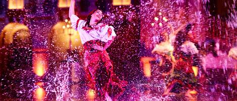 A person performing in a traditional dance with water effects.