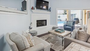Een moderne woonkamer met een open haard, een flatscreen televisie en comfortabele zitplaatsen.