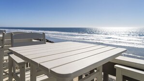 A white wooden table and chair set on a balcony overlooking the ocean. - Oceanfront Home w/ Panoramic Views & Private Beach (Oceanside,)
