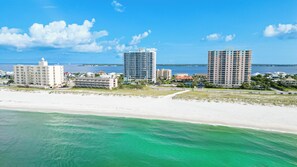 A coastal cityscape with beachfront hotels, clear skies, and a view of the ocean.