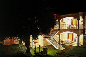 A two-story building with a balcony and a staircase leading to the upper floor.