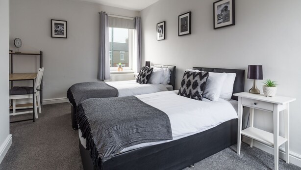 A hotel room with two beds, a desk, and a window. - Hawthorn- Great 2 bed home in Ashington, Northumberland (Ashington)