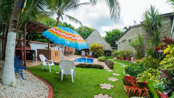 Alberca al aire libre, sombrillas en la alberca y camastros