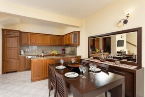 Una cocina moderna con armarios de madera, encimera de granito y un comedor con un espejo grande.