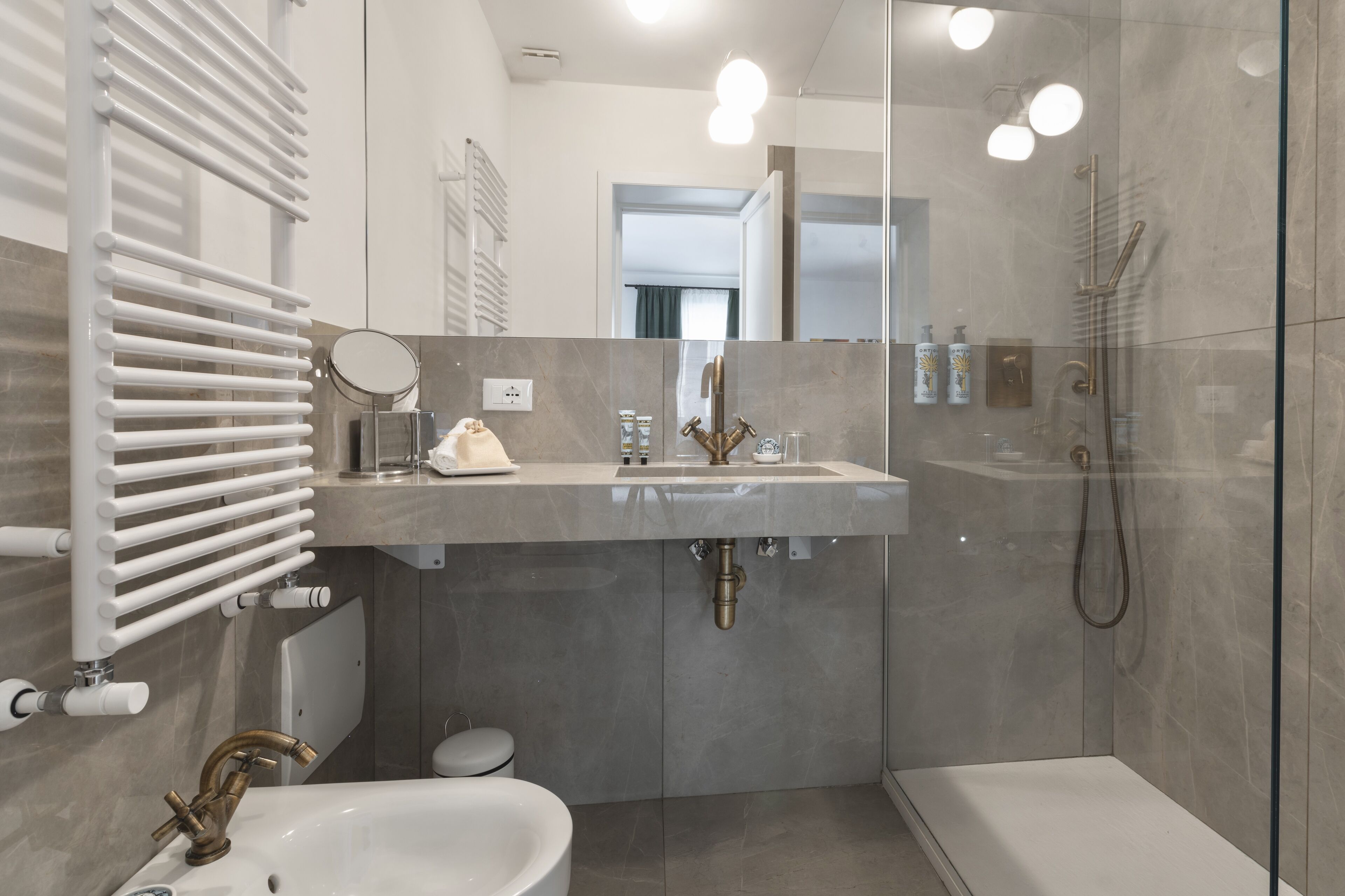 Un bagno moderno con doccia vetro, mobile lavabo e servizi igienici.