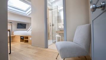 A modern bedroom with a skylight, a shower, and a bed.