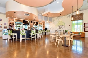 A coffee bar with seating and a bar counter, surrounded by wooden chairs and tables.