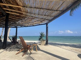 Na praia, areia branca, espreguiçadeiras, prática de mergulho autônomo 