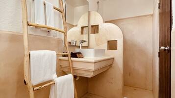 Un baño con una escalera de madera, un lavamanos y un espejo.