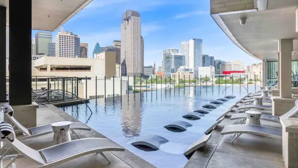 A rooftop pool with modern seating and a city skyline view. - GoodLUXCharm Luxury 2B2B In Deep Ellum Rftp Pool (Dallas)