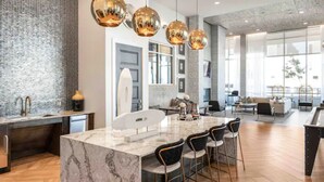 A modern kitchen with a marble island, bar stools, and pendant lighting. - GoodLUXCharm Luxury 2B2B In Deep Ellum Rftp Pool (Dallas)