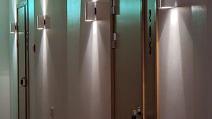 A hallway with doors, each with a light switch and a lock. - Hotell Bro (Kristinehamn)