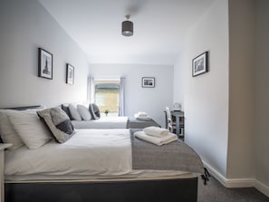 Un dormitorio con una cama, un escritorio y una ventana.