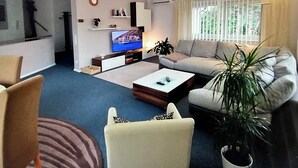 A modern living room with a sofa, coffee table, and TV. - Vacation apartment Freiburg surroundings - FELDSCHLÖSSCHEN in March (March)