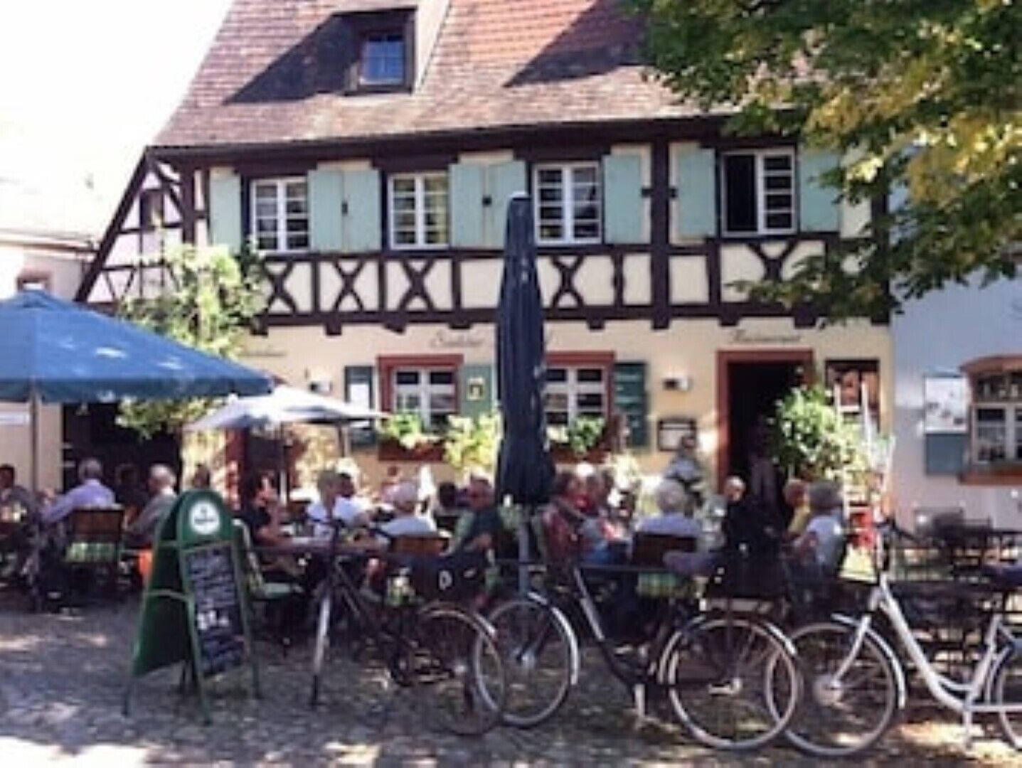A traditional half-timbered building with outdoor seating and bicycles parked in front.