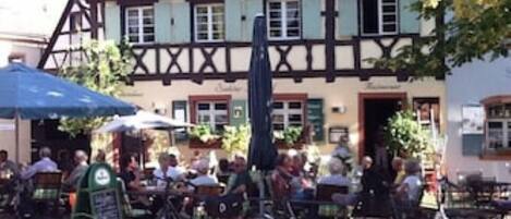A traditional half-timbered building with outdoor seating and bicycles parked in front.