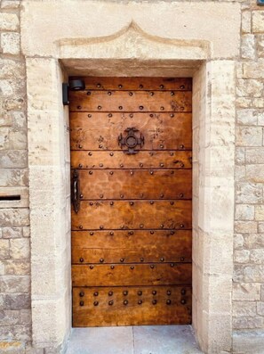 A wooden door with metal studs and a central knob, set in a stone wall. - La Maîtrise, in the heart of Bayeux Les Maisons des Pommiers (Bayeux)