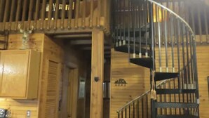 Ein Holzinne mit einer Wendeltreppe und einer Küchenzeile.