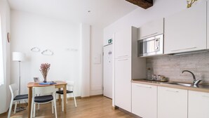 Eine moderne Küche mit weißen Schränken, einer Edelstahl-Mikrowelle und einer Holzauskład.