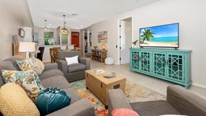 A living room with a sofa, coffee table, and a television on a cabinet.