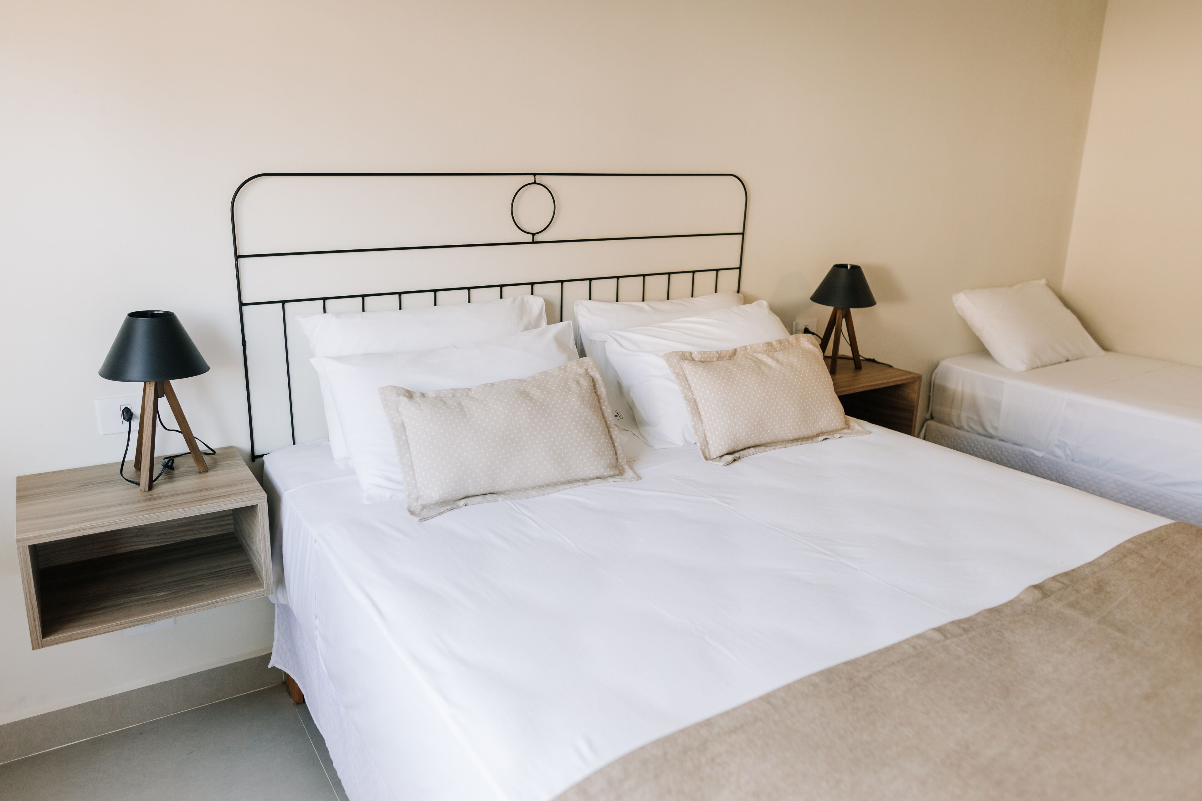 A bedroom with a bed, bedside tables, and lamps.