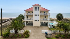 A multi-story beachfront building with balconies, a pool, and a sandy beach area. - Beach Buzz: Beachfront, Private Pool, Hot Tub (St. George Island)