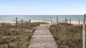 A wooden boardwalk leading to a beach with a fence on either side. - Beach Buzz: Beachfront, Private Pool, Hot Tub (St. George Island)