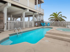 A swimming pool with a white deck, a hot tub, and a palm tree in the background. - Beach Buzz: Beachfront, Private Pool, Hot Tub (St. George Island)