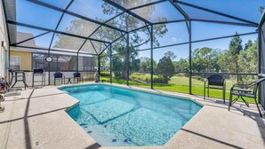 A covered outdoor swimming pool with a clear view of the surrounding landscape. - Beautiful 3-bedroom house, with private pool, backing onto golf course (Haines City)