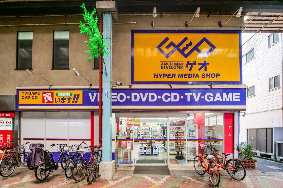Ein Schaufenster mit einem Schild für einen Hyper Media Shop, der eine große Auswahl an Medienprodukten präsentiert.
