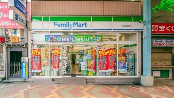A FamilyMart store with a tiled pavement outside.