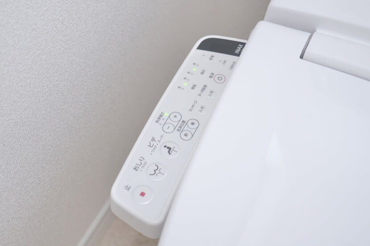 A white toilet with a control panel featuring Japanese instructions.