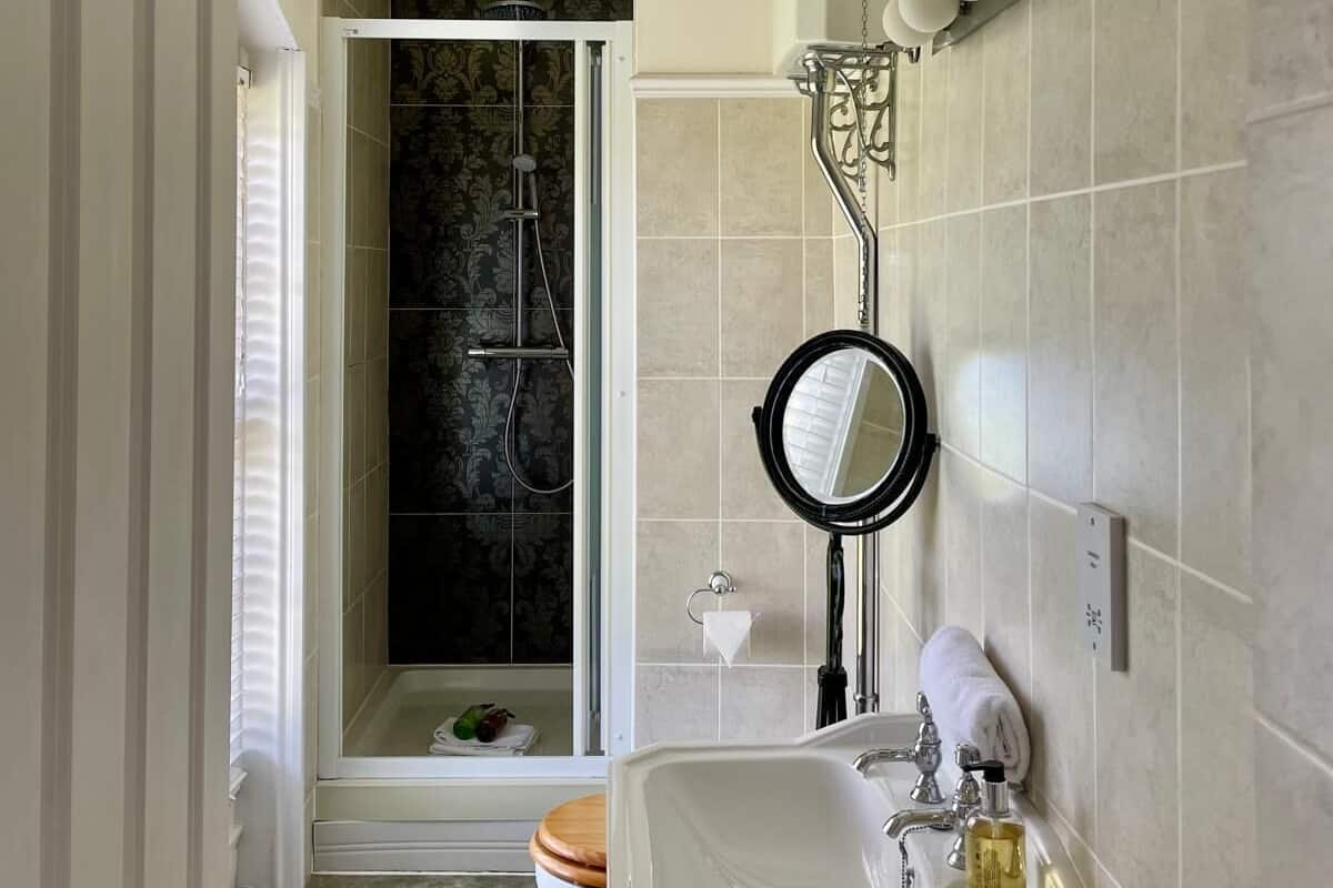 Ein Badezimmer mit Dusche, Toilette, Waschbecken und Spiegel.