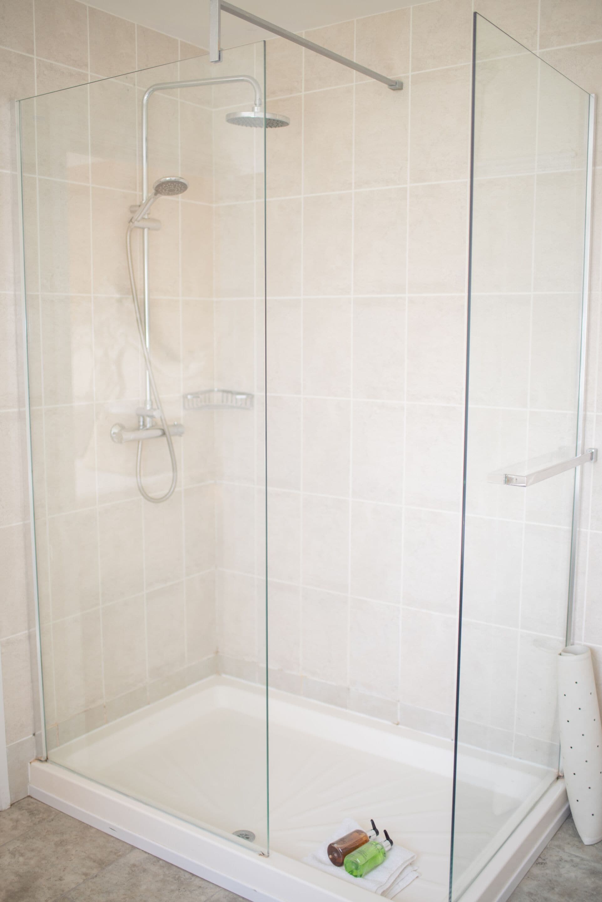 A glass-enclosed shower area with a glass door and a showerhead.