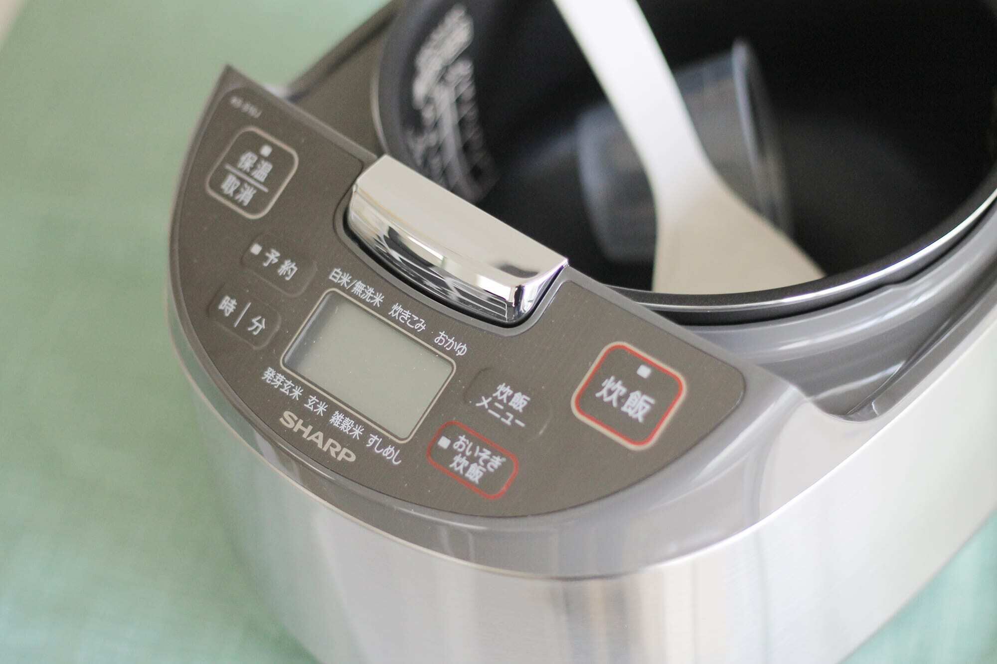 A rice cooker with a digital display and multiple buttons.