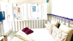 Un dormitorio con una cama, una ventana y un televisor.