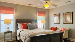 A bedroom with a bed, bedside tables, a ceiling fan, and artwork on the walls. - New! Charming Townhome 3 Minutes to Campbell (Lillington)