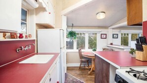 A compact kitchen with a sink, stove, and dining area.