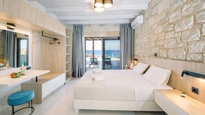 A modern bedroom with a large bed, a desk, and a view of the sea. - Villa Corallium in Sfinari - 5 min from the beach (Sfinari)