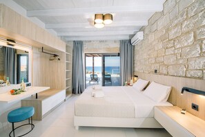 A modern bedroom with a large bed, a desk, and a view of the sea. - Villa Corallium in Sfinari - 5 min from the beach (Sfinari)