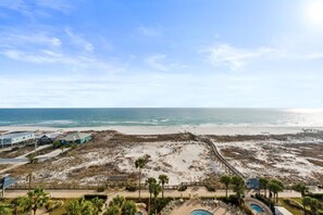 A beach resort with a pool, beach access, and a view of the ocean. - Beachfront Condo with On-Site Dining & Spa (Gulf Shores)