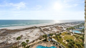 Um resort com vista para a praia, piscina e calçadão.