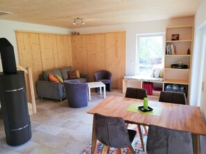 Una sala acogedora con una pared de madera, un sofá, una mesita de centro y una estantería.