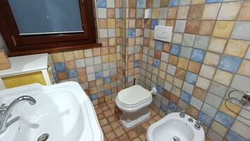 Un baño con lavamanos, inodoro y bidé.