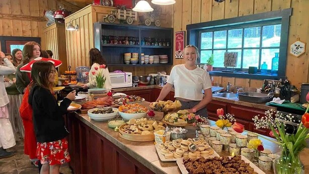 Ein reichhaltiges Buffet mit verschiedenen Speisen und einer Person, die bedient.