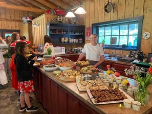 A buffet setup with various food items and a person serving.